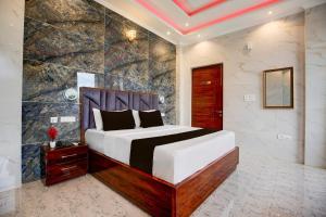 a bedroom with a bed and a stone wall at Super Townhouse by OYO Chandigarh Near PEC-PGI-PU Formerly Hotel Paradise in Chandīgarh
