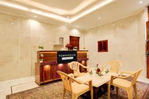 a room with a table and chairs and a television at Super Townhouse by OYO Chandigarh Near PEC-PGI-PU Formerly Hotel Paradise in Chandīgarh