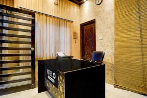 una scrivania nera con una sedia in una hall di Hotel O Dehradun City Centre a Dehradun