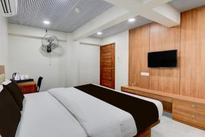 um quarto com uma cama e uma TV de tela plana em Super Hotel O Pune Kasarwadi Railway Station em Pune mais 23 fotografias