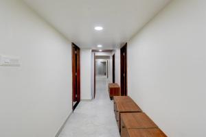 um corredor com bancos de madeira em um edifício em Super Hotel O Pune Kasarwadi Railway Station em Pune