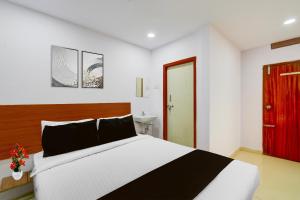 a bedroom with a large bed and a red door at Super Collection O L.B Nagar Metro Station Formerly D N Groups in Surūrnagar +25 photos