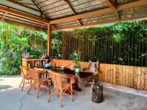 a patio with a wooden fence and a table and chairs at Jinghong Manyun Dai Village Inn in Jinghong