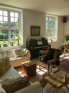 Historic Manor House At Gelskov Estate في Sandholts-Lyndelse: غرفة معيشة مع أريكة وبيانو