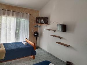 ein Schlafzimmer mit einem Bett und einem Fernseher an der Wand in der Unterkunft Casa Las Animas in El Carmen