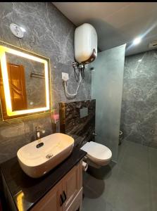a bathroom with a sink and a toilet and a mirror at Varlaxmi Vatika in Rānīkhet