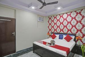 a bedroom with a bed and a ceiling fan at Hotel O Metro Inn in Noida
