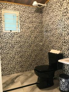 a bathroom with a black toilet and a sink at Cabana Gehrke in Nova Petrópolis
