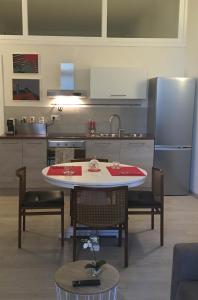 Una cocina con mesa y sillas y un refrigerador. en Appartamento Malabranca, en Orvieto