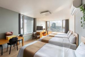 首尔现代住宅的一间带两张床和一张书桌的酒店房间