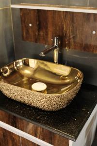 a bathroom with a gold sink on a counter at Hotel Materhorn in Kovalam +25 photos