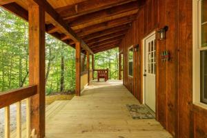 a porch of a log cabin with a wooden walkway at Pet-Friendly Tiny Cabin - Pine Point in Pine Ridge +50 photos