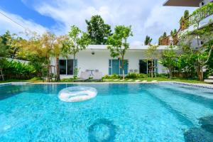 a pool with a float in front of a house at Sunny Blue Runway in Ban Nai Na