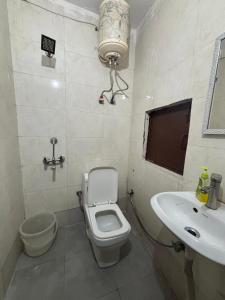 un baño con inodoro y lavabo en Hotel R Villa - Near Hauz Khas Fort, en Nueva Delhi