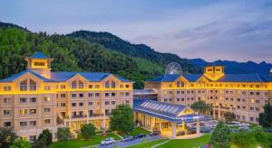 a large building with a mountain in the background at Deefly Yinrun Town Hotel in Deqing