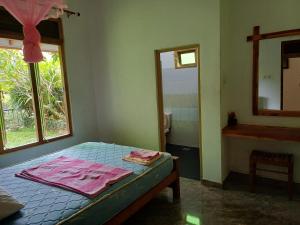 a bedroom with a bed with a window and a mirror at Elephant View Hotel in Damana