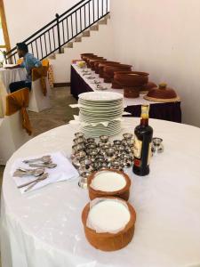 a table with white plates and a bottle of wine at Elephant View Hotel in Damana