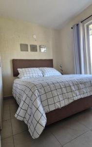 une chambre avec un lit avec une couverture et une fenêtre dans l'établissement Habitación Alta California con Alberca y Coto privado, à Tlajomulco de Zúñiga