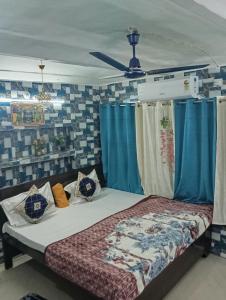 a bedroom with a bed with blue curtains at Luv Kush Homestay l free Tea & Coffee l in Ayodhya