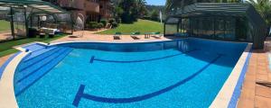 a large swimming pool with blue water at Basque Palace, Mansion con Jardín, Barbacoa, Gimnasio, Piscina, Sauna in Mungia