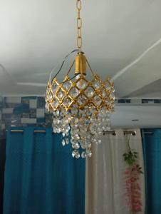 a gold and white chandelier hanging from a ceiling at Luv Kush Homestay l free Tea & Coffee l in Ayodhya