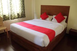 a bedroom with a large bed with red pillows at Life style home stay in Kodaikānāl