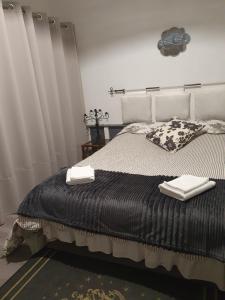 ein Schlafzimmer mit einem Bett mit schwarzen und weißen Decken in der Unterkunft La Maison de Jeanne in Lesparre-Médoc