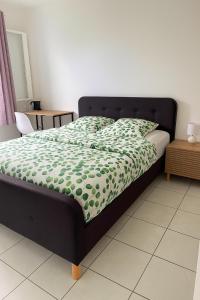 a bedroom with a bed with a green comforter at Chambres chez l'habitant in Saint-Paul