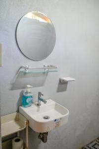 a bathroom with a sink and a mirror at Love Shack Hostel & Cafe in San Juan