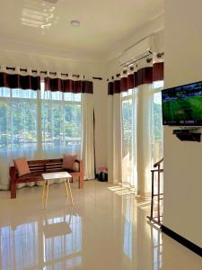 a living room with a couch and a tv and windows at Terrace Kandy in Kandy