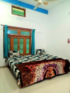 a large bed in a room with blue curtains at Shree Balaji home stay Ayodhya contact number 92782-97365 in Ayodhya