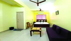 a living room with a couch and a bed at Hotel Avisha in Kolkata