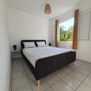 a bedroom with a large bed with a window at Chambres chez l'habitant in Saint-Paul