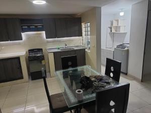 ククタにある2 habitaciónes 3 bañosのキッチン(ガラスのテーブル、シンク付)