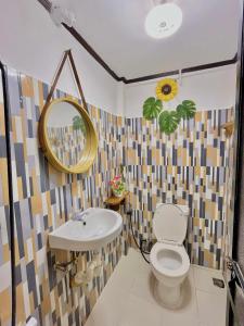 a bathroom with a sink and a toilet and a mirror at Precious Homestay - Serenity Room in Burgos