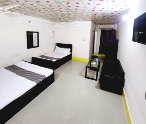 a room with two beds and a table in it at W Hotel Sylhet in Sylhet