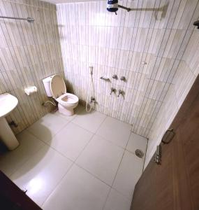 a bathroom with a toilet and a sink at W Hotel Sylhet in Sylhet