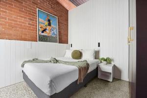 a bedroom with a bed and a brick wall at The Milliner - Boutique Living, Geelong West in Geelong West