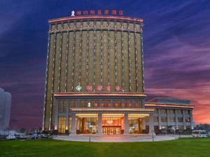 a large building with a lit up tower at night at Venus Royal Hotel Anhui Tongcheng Tongguoxiushui in Wangguolu