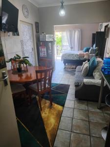 a living room with a table and a dining room at Primrose Accommodation in George