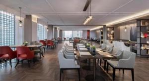 a restaurant with wooden tables and white chairs at Echeng Hotel Nanning the Mixc Convention in Nanning