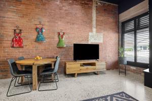 The Radford on Elizabeth في Geelong West: غرفة معيشة فيها تلفزيون وجدار من الطوب +5 صور
