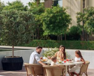 uma família sentada à mesa a comer em Al Zorah Beach Resort em Ajman