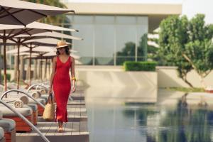 uma mulher de vestido vermelho ao lado de uma piscina em Al Zorah Beach Resort em Ajman mais 69 fotografias