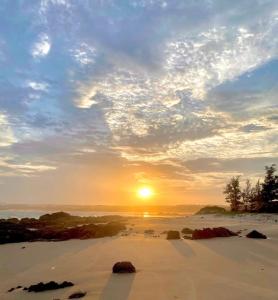 a sunset on a beach with the sun in the sky at Homestay Nhà Của Gạo in Ấp Thiẹn Ái