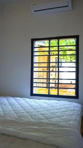 a bedroom with a bed and a large window at Homestay Nhà Của Gạo in Ấp Thiẹn Ái