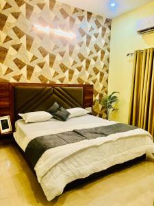 a bedroom with a large bed with a geometric wall at Heaven hill Pushkar in Pushkar