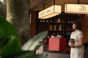 a woman standing in front of a coffee shop at Yinshi Yunshe Private Hot Spring Villa in Dujiangyan in Dujiangyan