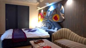 a hotel room with a bed and a table and a chair at ホテル うさぎ -岡山運転免許センター南- 