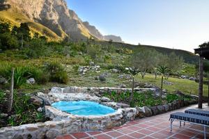 ein kleiner Teich auf einem Feld mit einem Berg in der Unterkunft Peak Cottage in Franschhoek
